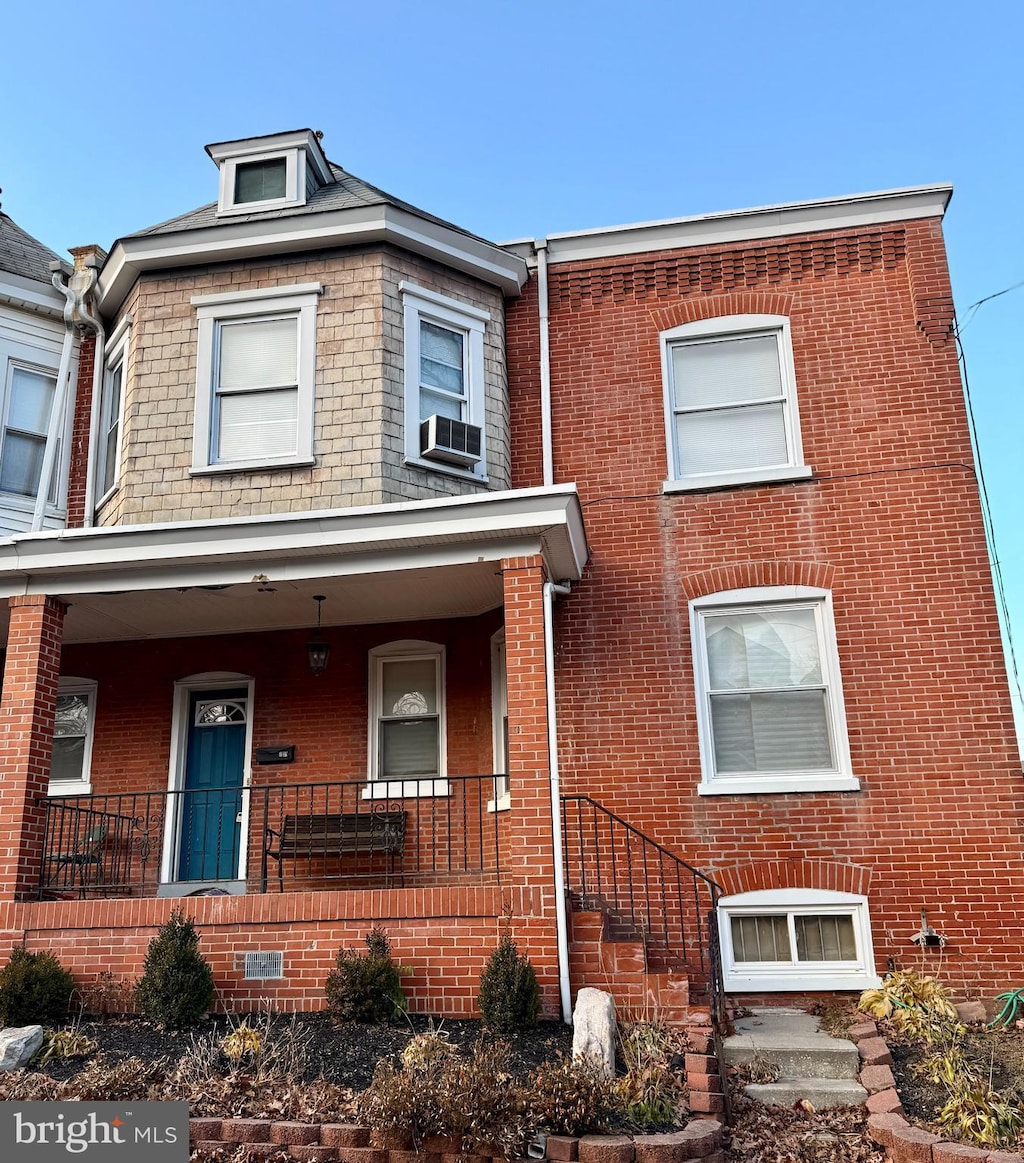 townhome / multi-family property with cooling unit and covered porch