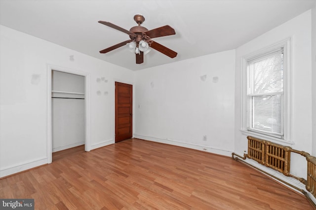 unfurnished bedroom with ceiling fan, two closets, and light wood-type flooring