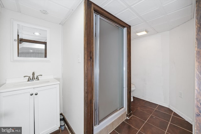 bathroom with tile patterned floors, toilet, an enclosed shower, and vanity