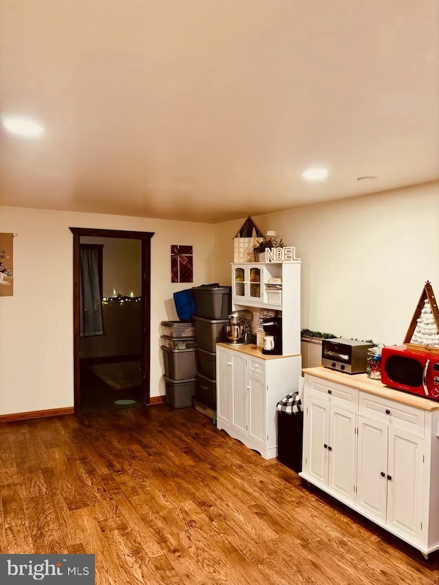 kitchen featuring hardwood / wood-style flooring and white cabinetry