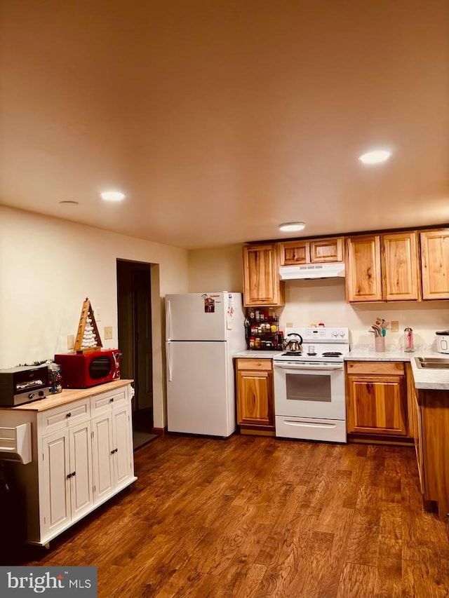 kitchen featuring sink, white appliances, and dark hardwood / wood-style floors