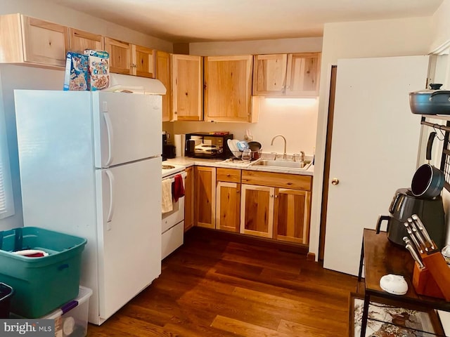 kitchen featuring light brown cabinetry, sink, white appliances, and dark wood-type flooring