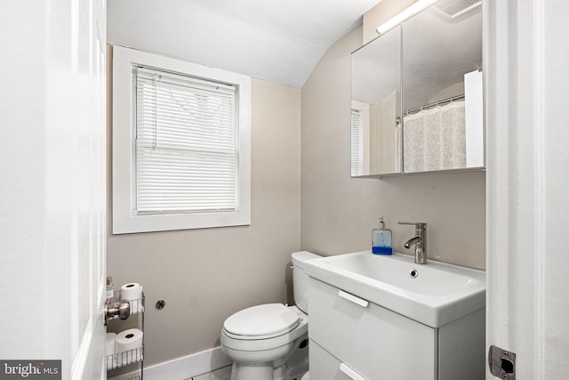 bathroom featuring vanity, toilet, and lofted ceiling