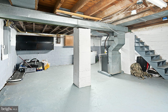 basement featuring heating unit and washer / dryer