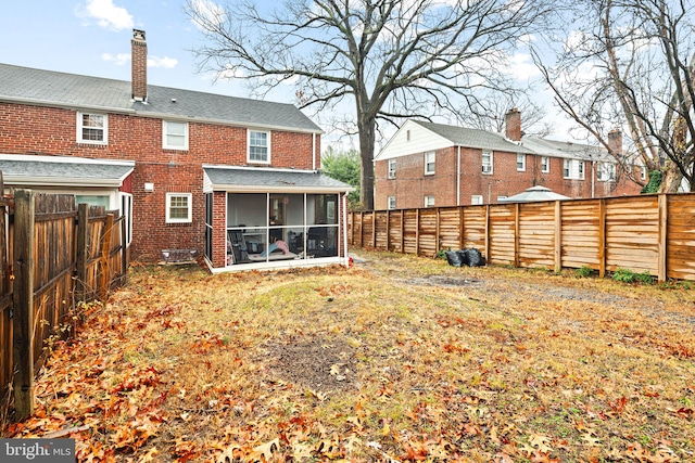 back of house featuring a sunroom and a yard