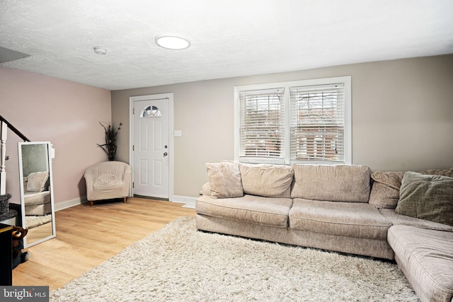 living room with light hardwood / wood-style floors and a textured ceiling