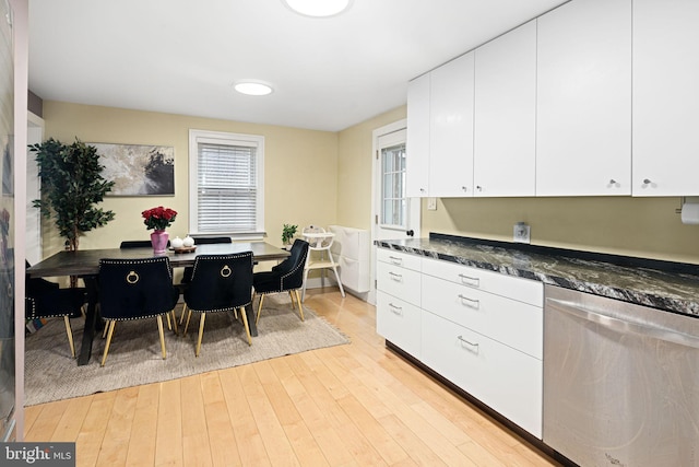 kitchen with white cabinets, light hardwood / wood-style flooring, and dark stone countertops