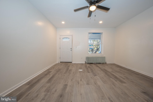 interior space with ceiling fan, light hardwood / wood-style floors, and radiator heating unit