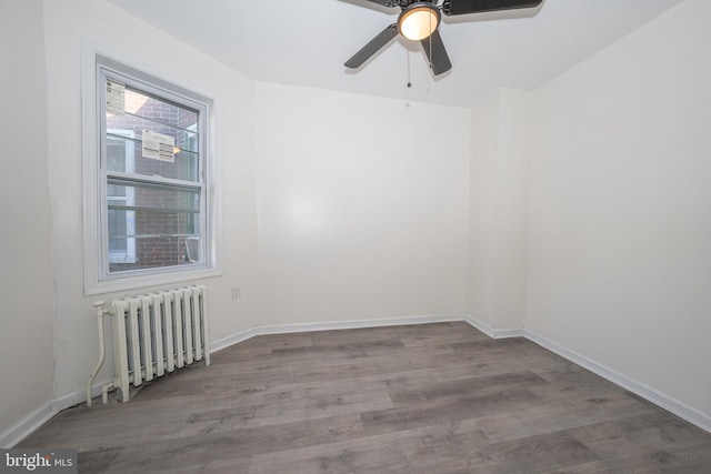 unfurnished room with ceiling fan, radiator heating unit, and hardwood / wood-style floors