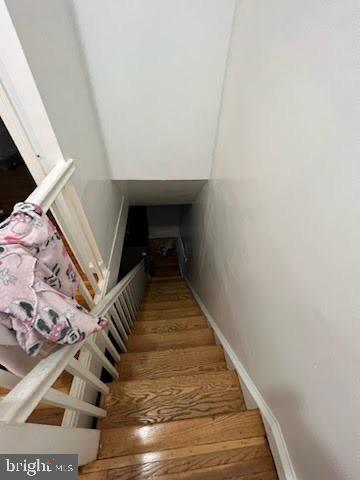 stairs featuring hardwood / wood-style floors