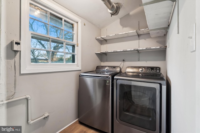 clothes washing area featuring washer and clothes dryer and light hardwood / wood-style flooring