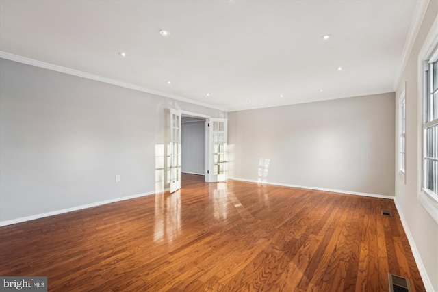 unfurnished room featuring hardwood / wood-style floors, crown molding, and french doors