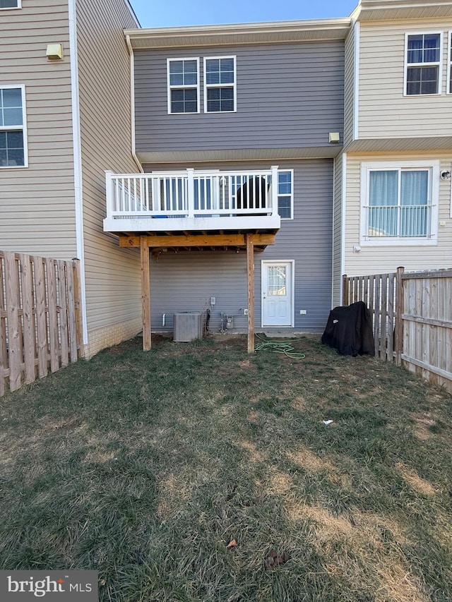 back of property with a yard and central AC unit