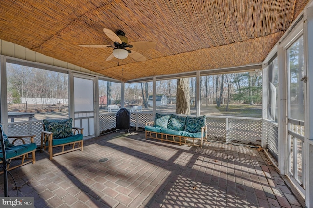 sunroom / solarium featuring ceiling fan, plenty of natural light, and lofted ceiling