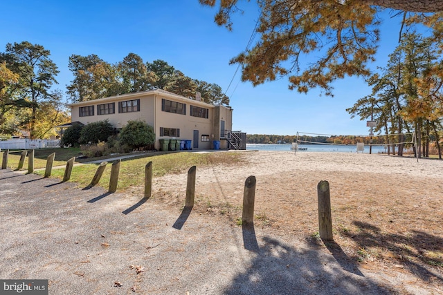 exterior space with volleyball court and a water view