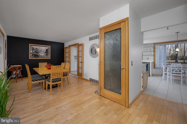 dining space featuring light wood-type flooring and french doors