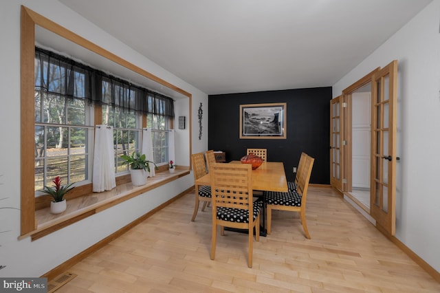 dining space featuring light hardwood / wood-style floors and french doors