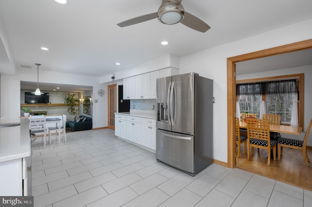 kitchen with pendant lighting, stainless steel fridge with ice dispenser, ceiling fan, tasteful backsplash, and white cabinetry