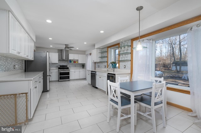 kitchen with white cabinets, decorative light fixtures, stainless steel appliances, and ceiling fan