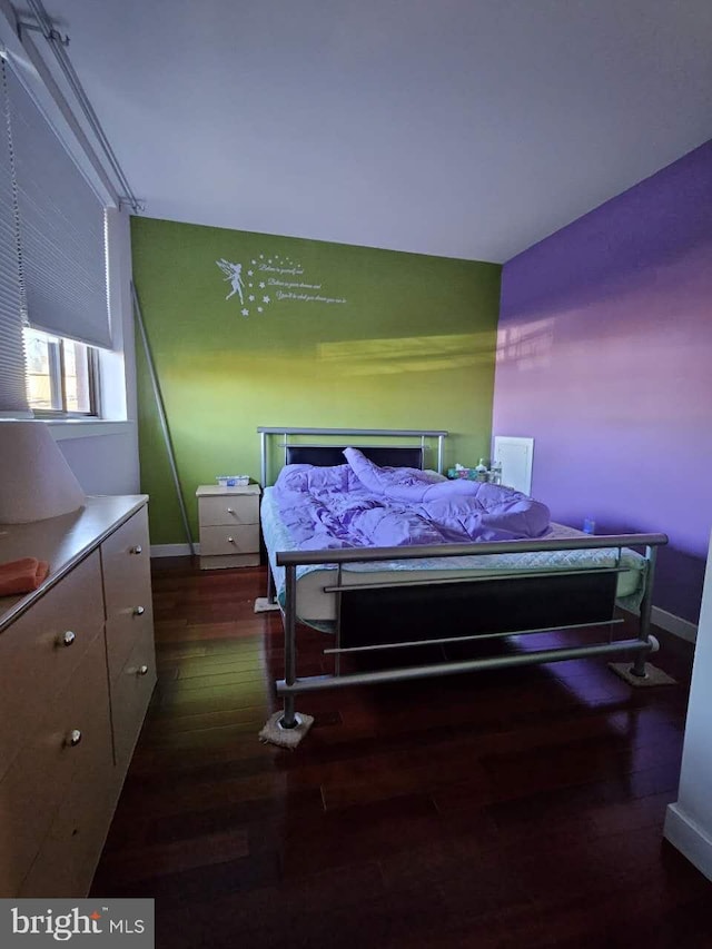 bedroom with dark hardwood / wood-style flooring