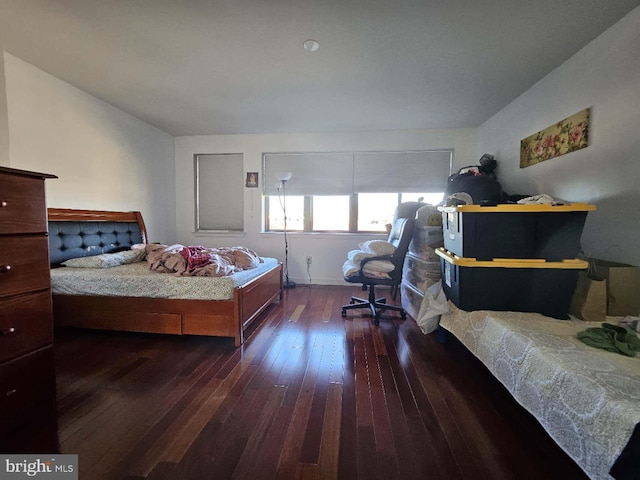 bedroom with dark hardwood / wood-style flooring