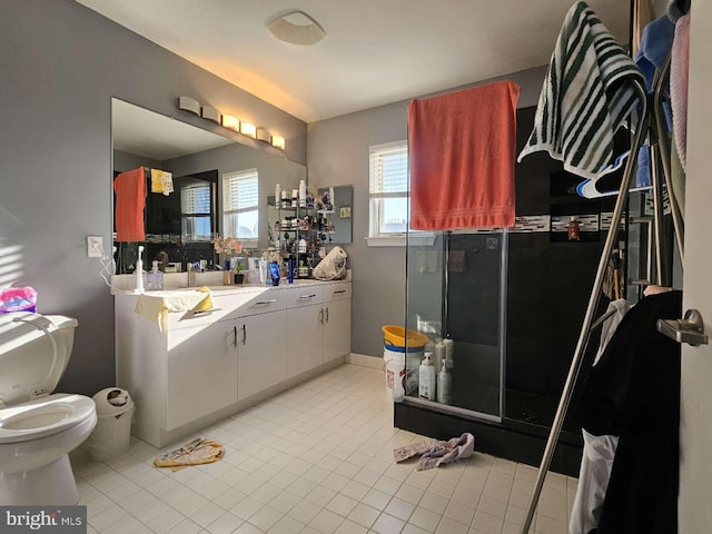 bathroom with tile patterned floors, vanity, a shower with shower door, and toilet