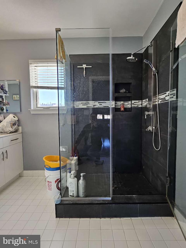 bathroom with tile patterned floors, vanity, and walk in shower