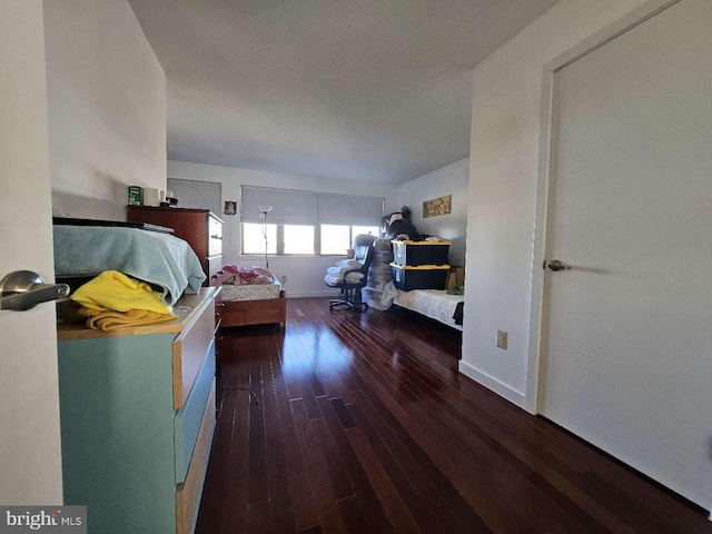 bedroom with dark hardwood / wood-style flooring