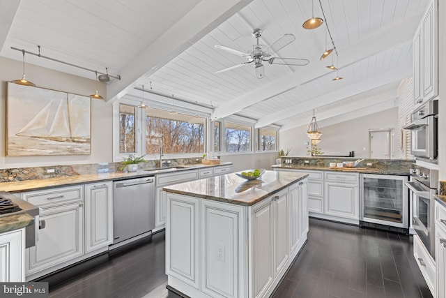 kitchen featuring a kitchen island, beverage cooler, white cabinets, and appliances with stainless steel finishes