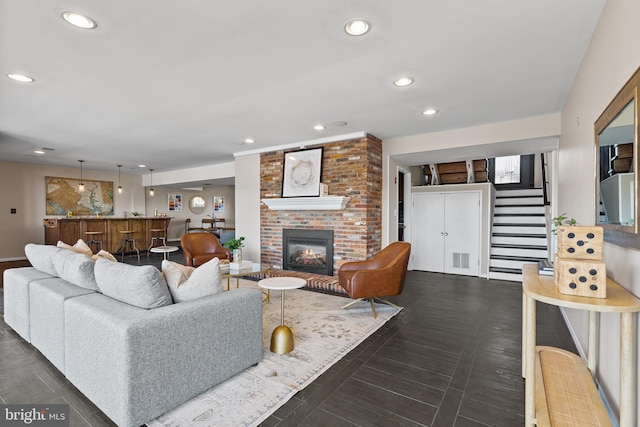 living room featuring a brick fireplace and bar