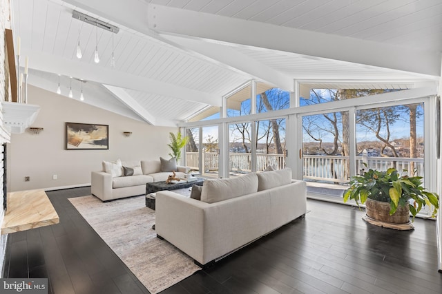 living room with dark wood-type flooring, track lighting, and lofted ceiling with beams