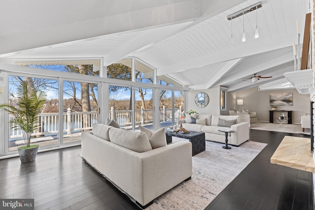 living room with dark hardwood / wood-style flooring, plenty of natural light, and lofted ceiling with beams