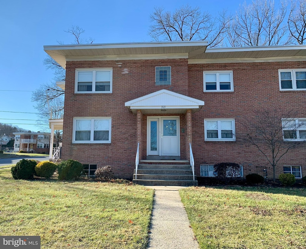 townhome / multi-family property featuring a front lawn