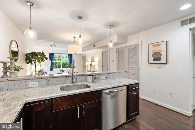 kitchen with pendant lighting, dishwasher, sink, light stone countertops, and dark hardwood / wood-style flooring