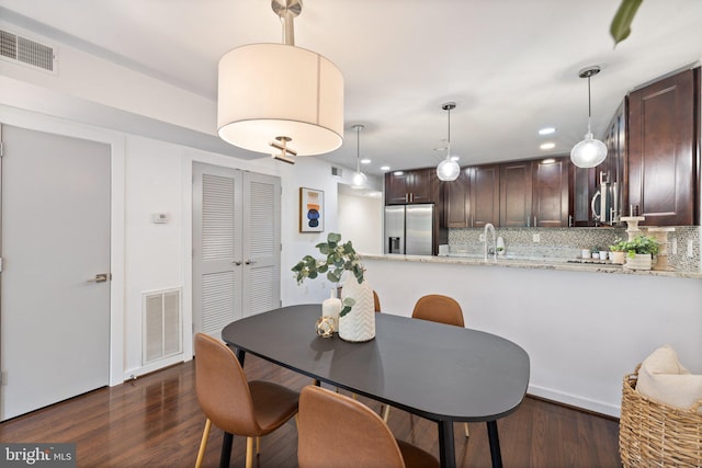 dining space with dark hardwood / wood-style floors and sink