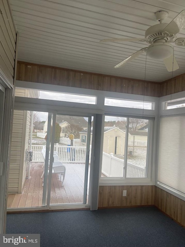 unfurnished sunroom featuring ceiling fan