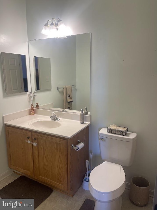 bathroom with tile patterned flooring, vanity, and toilet