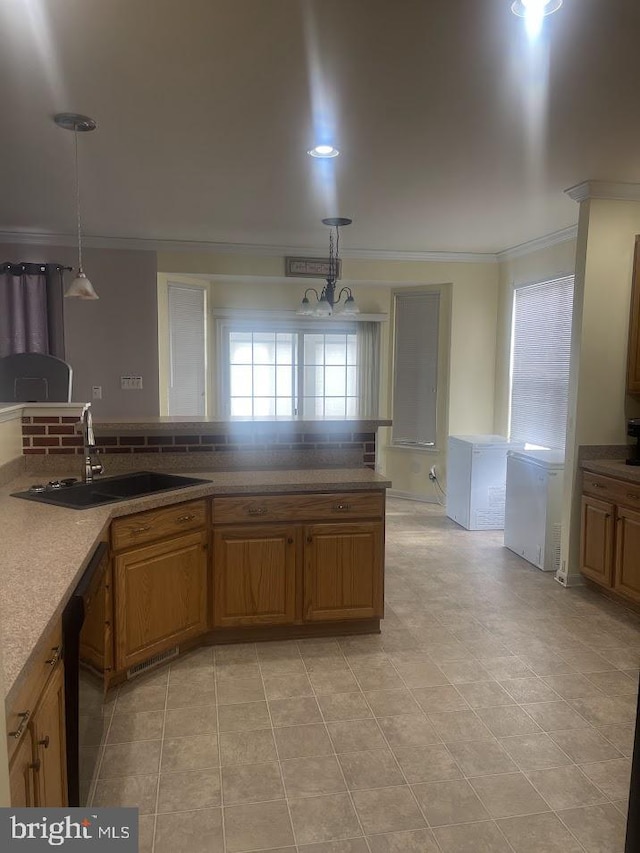 kitchen with a notable chandelier, decorative light fixtures, ornamental molding, and sink