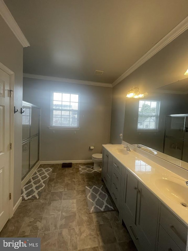 bathroom with toilet, vanity, an enclosed shower, and ornamental molding