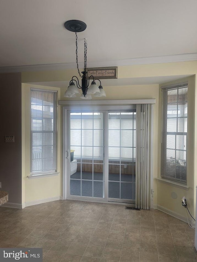 unfurnished dining area with a notable chandelier, crown molding, and a wealth of natural light