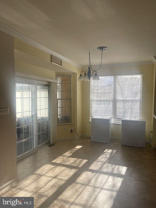 unfurnished dining area featuring crown molding and an inviting chandelier