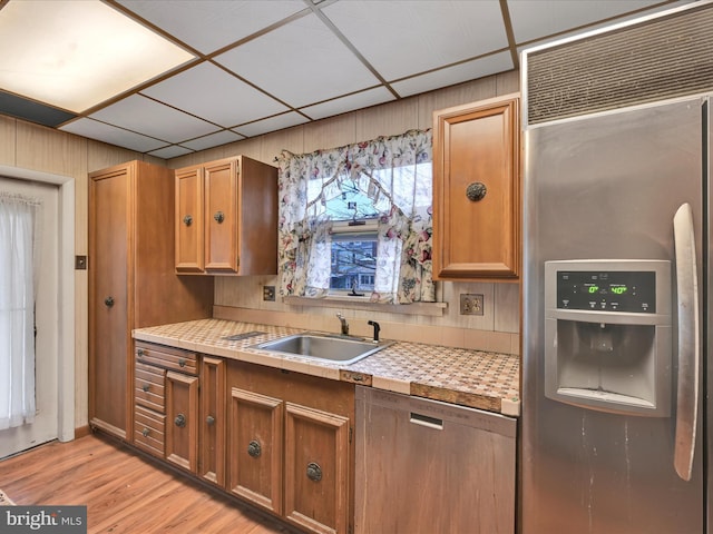 kitchen featuring light hardwood / wood-style floors, stainless steel built in fridge, a drop ceiling, and sink