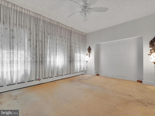 unfurnished room featuring ceiling fan and a baseboard radiator