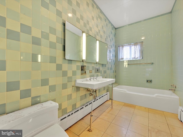 bathroom featuring a bathing tub, sink, a baseboard heating unit, tile patterned floors, and toilet