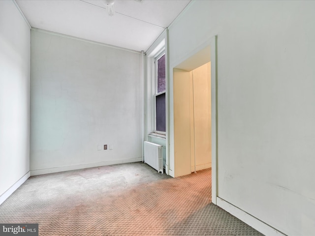 carpeted spare room featuring radiator heating unit