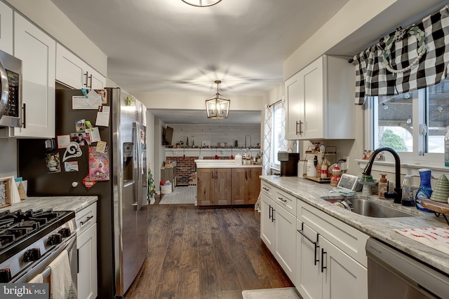 kitchen featuring light stone countertops, white cabinetry, sink, and stainless steel appliances