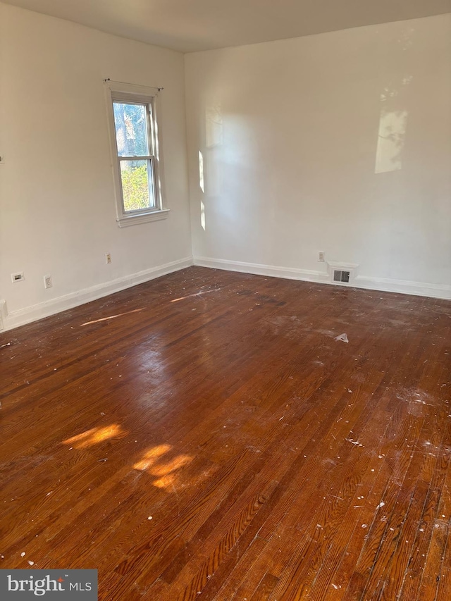 unfurnished room with dark wood-type flooring