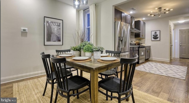 dining space featuring light hardwood / wood-style floors and a chandelier