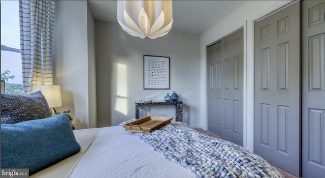 bedroom featuring a notable chandelier and multiple closets