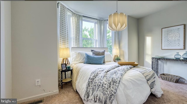 carpeted bedroom featuring a chandelier